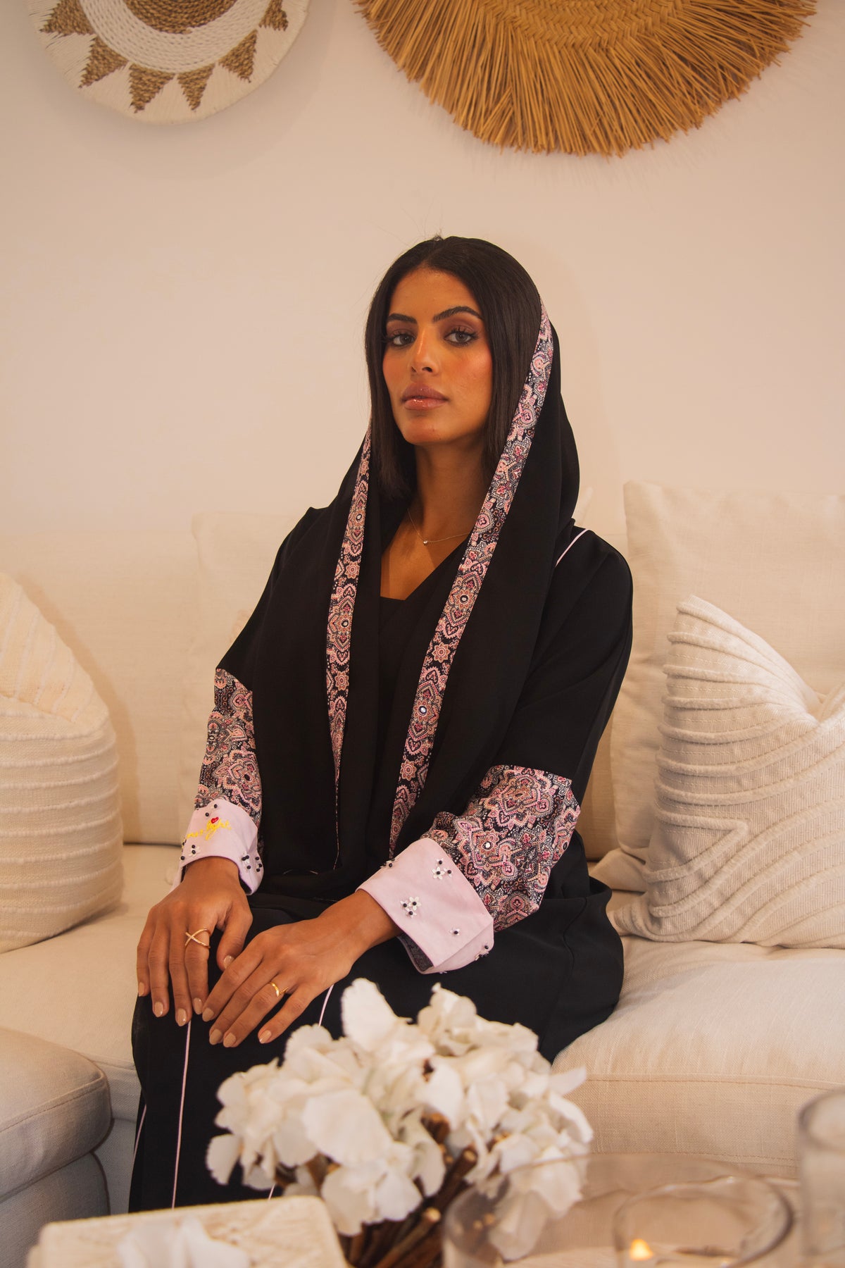 PEONISA Be Your Light black abaya with pink patterned front trim and contrasting pink cuff details.