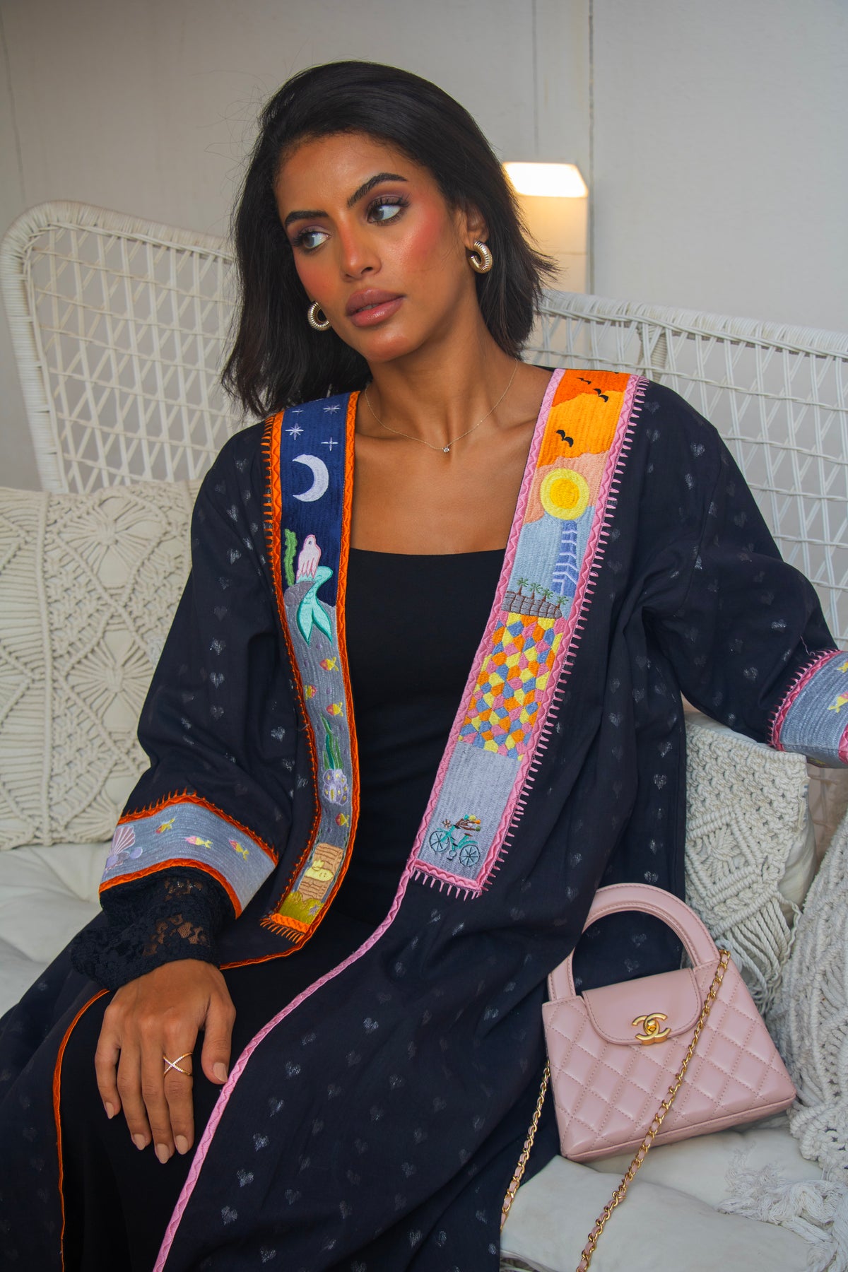 Close-up of PEONISA Jeddah Corniche black abaya showing colorful embroidered panels, sleeve detail and contrast edging.