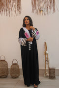 PEONISA Raneem black abaya with black-and-white striped sleeves and contrasting pink front detail.