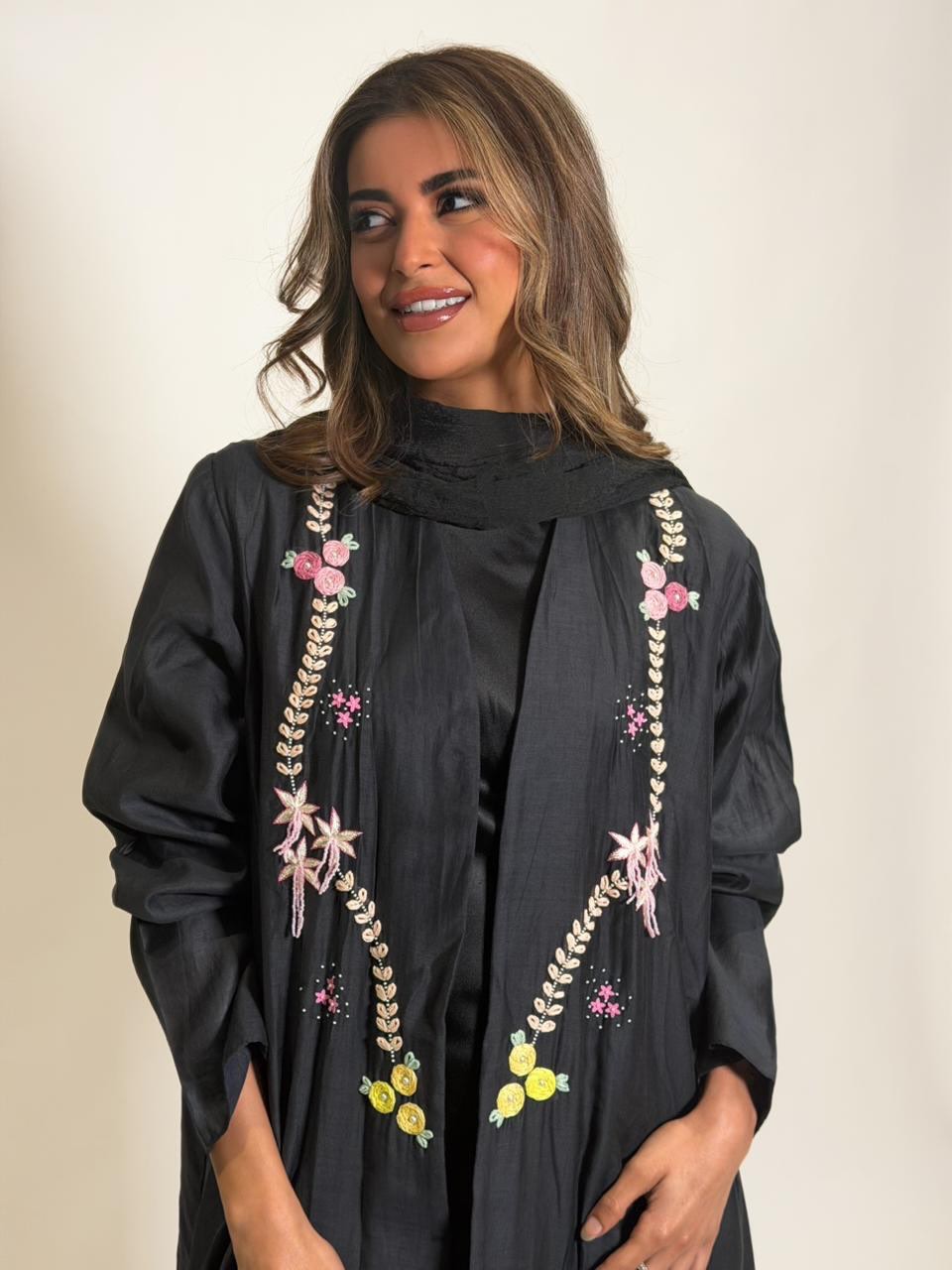 Rawd black abaya with delicate hand embroidery in pink, yellow and ivory details.