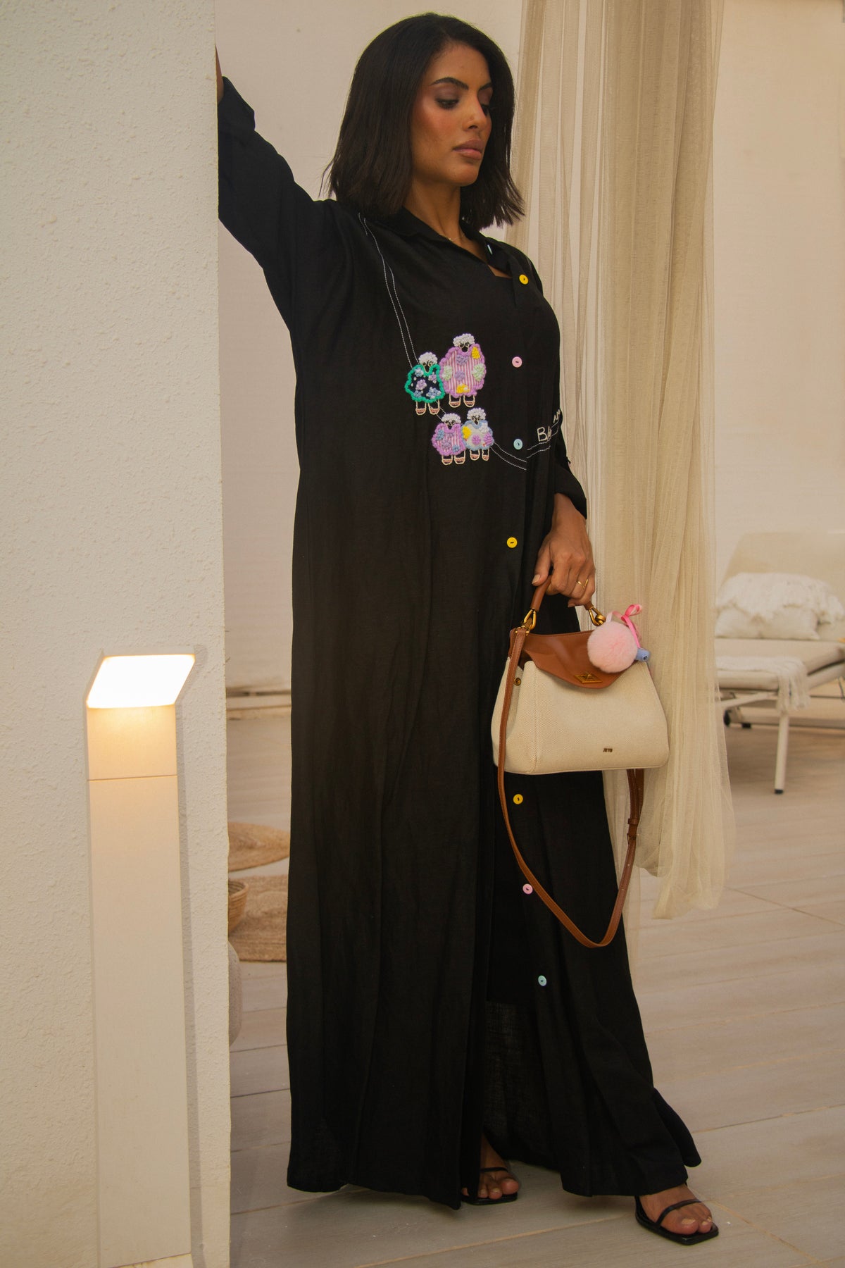 PEONISA Rifq black abaya with colorful embroidered motifs, contrast stitching and a full-length silhouette.