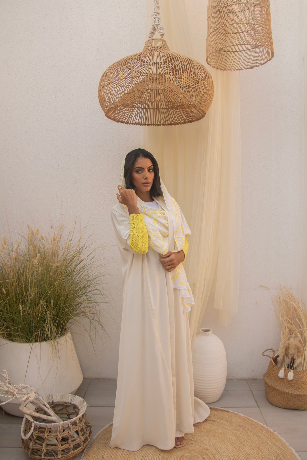 Full look of PEONISA Shorooq white abaya with yellow patterned scarf detail and contrasting yellow sleeves.