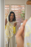 PEONISA Shorooq white abaya with yellow patterned scarf detail and contrasting yellow sleeve cuffs.