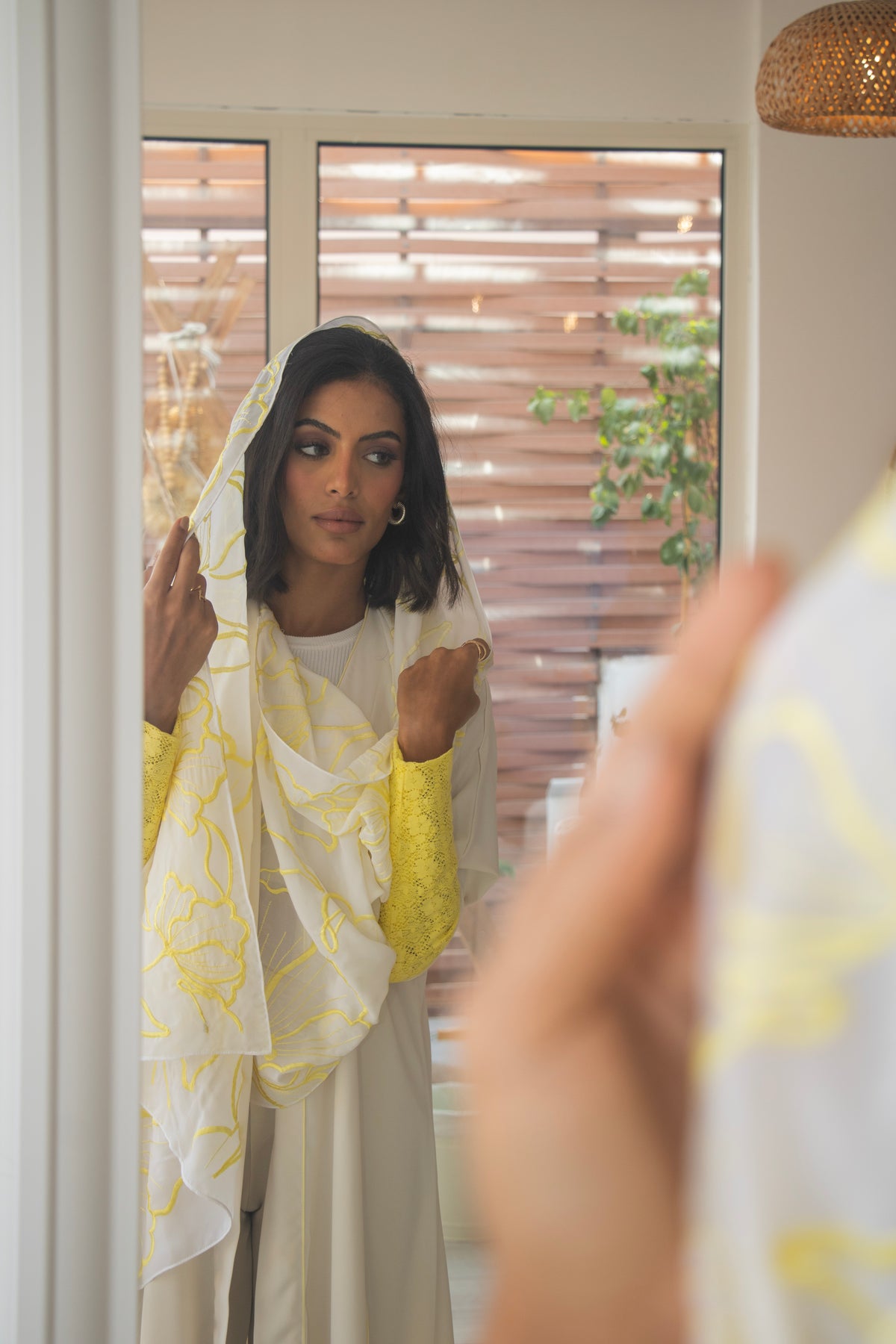 PEONISA Shorooq white abaya with yellow patterned scarf detail and contrasting yellow sleeve cuffs.