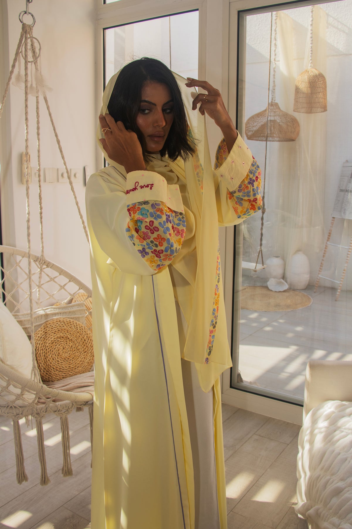 PEONISA Soleil pale yellow abaya with multicolor floral sleeve details and contrasting patterned front trim.